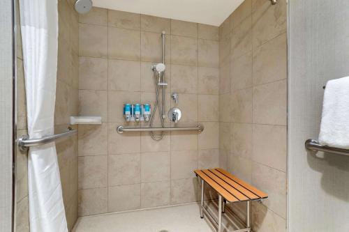 y baño con ducha y banco de madera. en Drury Inn Paducah en Paducah