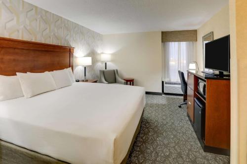 a hotel room with a large bed and a flat screen tv at Drury Inn & Suites Marion in Marion