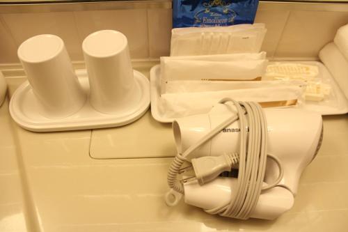 a white hair dryer sitting on top of a refrigerator at Hotel Saika in Fujisawa