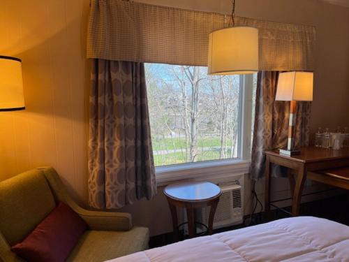 ein Hotelzimmer mit einem Bett und einem Fenster in der Unterkunft Arbor Inn - Weymouth in Weymouth