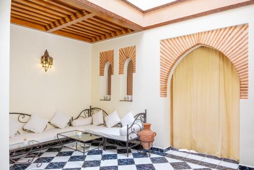 uma sala de estar com um sofá e uma mesa em Riad The Moroccans Pool And Terrace em Marrakech