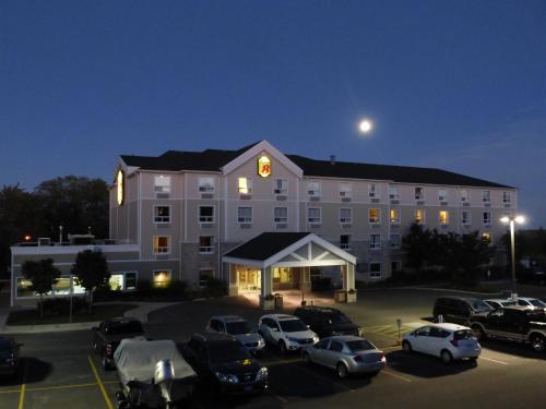 a large building with cars parked in a parking lot at Super 8 by Wyndham Peterborough in Peterborough