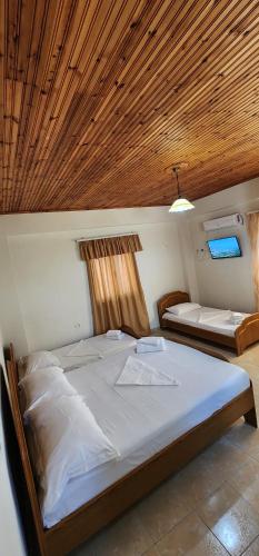 a bedroom with two beds and a wooden ceiling at Villa Bianca1 in Piqeras
