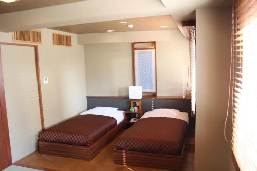 Un pat sau paturi într-o cameră la Hotel Saika