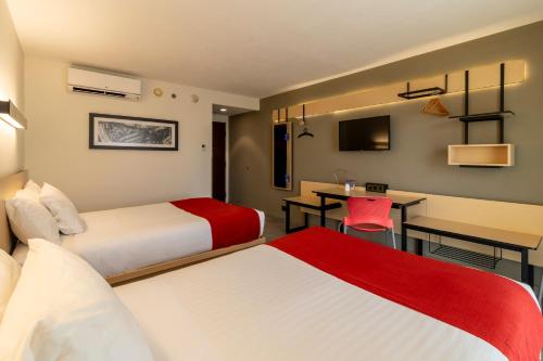 a hotel room with two beds and a desk at City Express by Marriott Salina Cruz in Salina Cruz