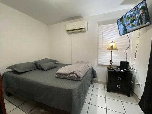 a bedroom with a bed and a flat screen tv at Casa empresarial 5 minutos de puente internacional in Reynosa