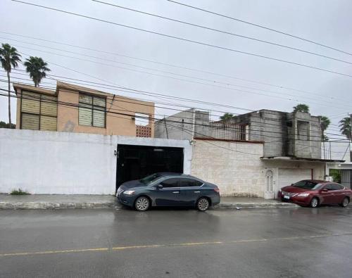 two cars parked in front of a garage at Casa empresarial 5 minutos de puente internacional in Reynosa