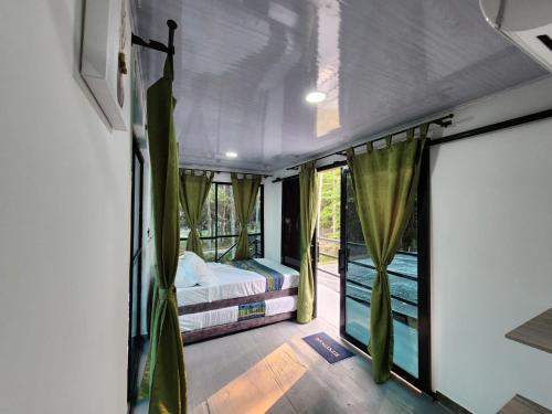 Pokój z 2 łóżkami i balkonem z oknami w obiekcie Encanto Llanero XKPDestinations. w mieście Villavicencio