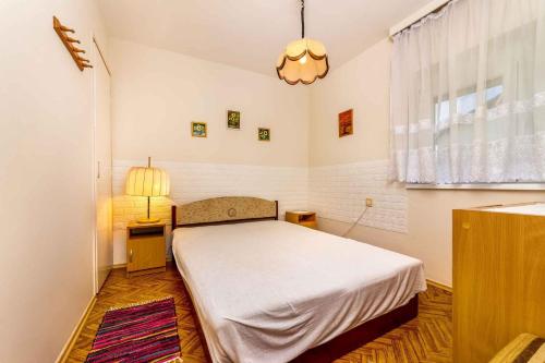 um quarto com uma cama, um candeeiro e uma janela em Holiday home in Balatonmariafürdo 45324 em Balatonmáriafürdő
