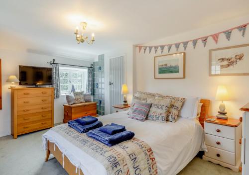 een slaapkamer met een bed met blauwe handdoeken bij Olive Tree Cottage in Portesham