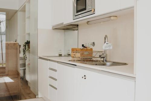 a kitchen with white cabinets and a sink at Apartment in Santos in Lisbon