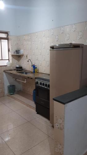 a kitchen with a stove and a counter in it at Apartamentos da Matriz in Piumhi