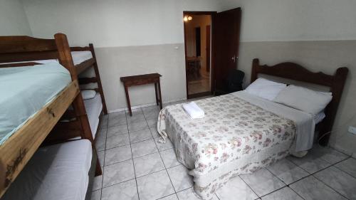 a small bedroom with two beds and a mirror at Apartamentos da Matriz in Piumhi