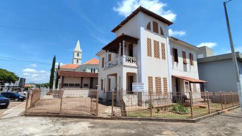un edificio blanco con una iglesia al fondo en Apartamentos da Matriz, en Piauí