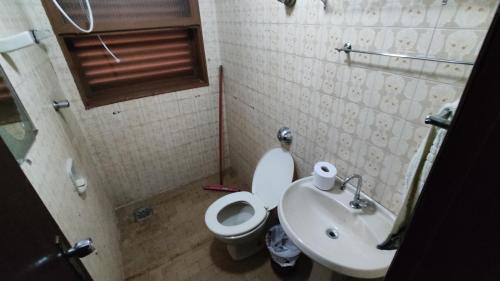 a small bathroom with a toilet and a sink at Apartamentos da Matriz in Piumhi
