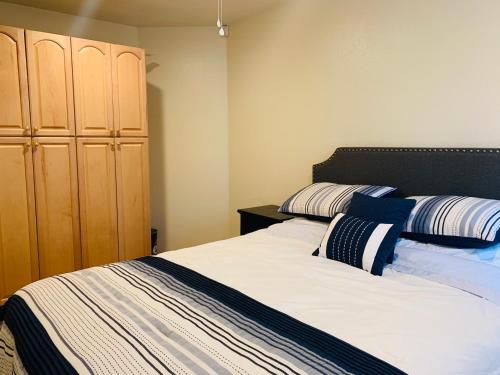 a bedroom with a bed and a wooden cabinet at Oasis with heated pool, mini golf, hot tub & barbq area in Oceanside