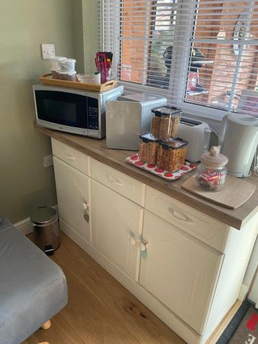 a counter with a microwave on top of it at Private en-suite RUTHIN in Llanfair-Dyffryn-Clwyd