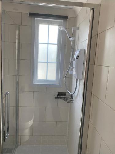 a shower in a bathroom with a window at Private en-suite RUTHIN in Llanfair-Dyffryn-Clwyd