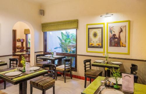 a restaurant with tables and chairs and a window at Home@F37 Kailash Colony Metro in New Delhi