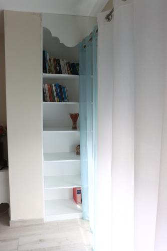 a room with a book shelf with books at Espaço Jandira in Fajã de Baixo