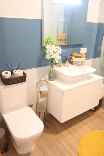 a bathroom with a white sink and a toilet at Espaço Jandira in Fajã de Baixo