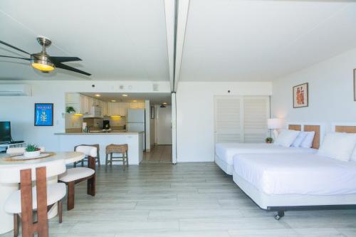ein Schlafzimmer mit einem Bett und einem Tisch sowie eine Küche in der Unterkunft Ilikai Tower 1744 Yacht Harbor View 2BR in Honolulu