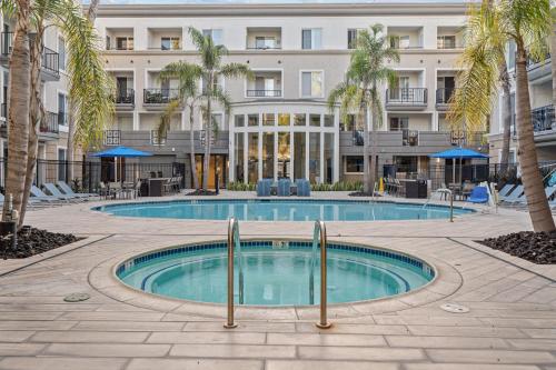 a pool in front of a building with palm trees at Luxury 2BDR with Parking & Pool - Marina del Rey in Los Angeles