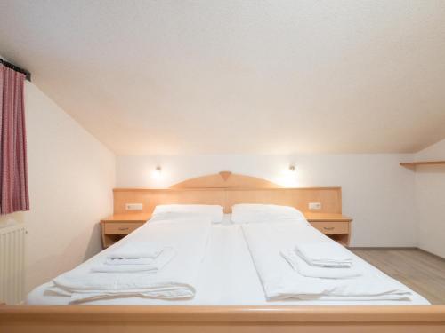 a bedroom with a large bed with white sheets at Vanessa in Zell am See