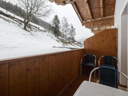 a porch with two chairs and a snow covered slope at Jürgen in Zell am See