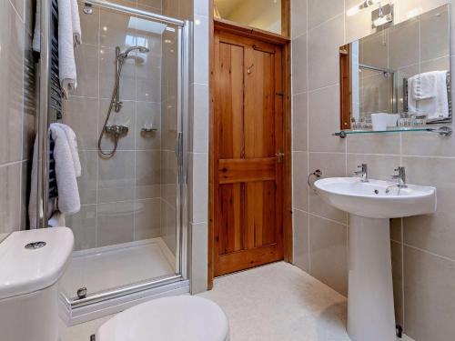 een badkamer met een douche, een toilet en een wastafel bij 2 Bed in Helston ROSEB in Wendron