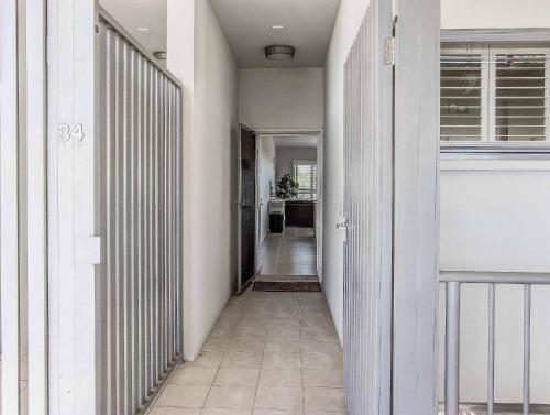 a hallway with white walls and a tile floor at Drift North Beachfront Apartments - Private Apartments in Kingscliff