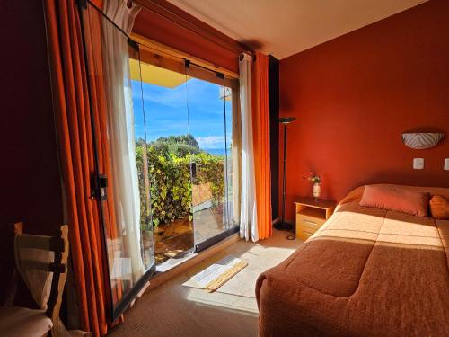 a bedroom with a bed and a large window with a view at Hotel Pumakala in Puno