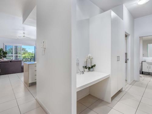 a white bathroom with a sink in a room at Drift North Beachfront Apartments - Private Apartments in Kingscliff