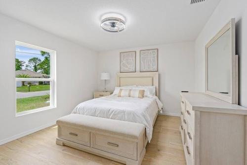 a white bedroom with a bed and a window at spacious 4-bedroom WITH KING BED in Palm Coast