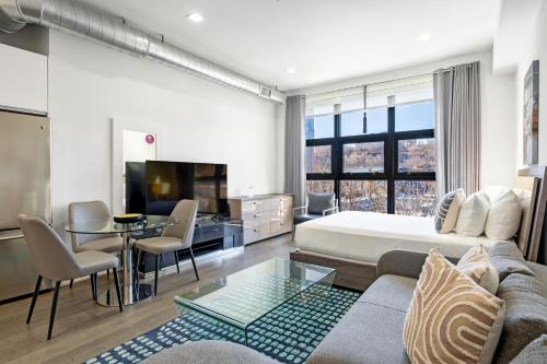 une chambre d'hôtel avec un lit et un salon dans l'établissement Dharma Home Suites Hoboken, à Hoboken