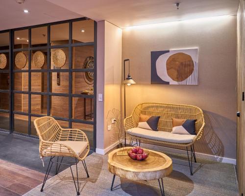 a living room with two chairs and a table at The Artisan D.C. Hotel, Autograph Collection in Bogotá
