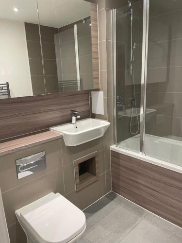 ein Bad mit einem Waschbecken, einem WC und einer Dusche in der Unterkunft Luxurious 2 Bedroom Apartment in Barking
