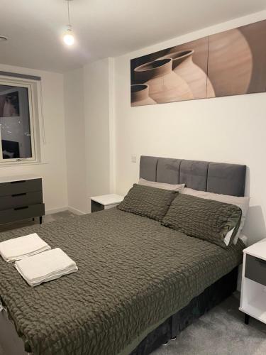Luxurious 2 Bedroom Apartment في باركينغ: غرفة نوم بسرير كبير ولوحة على الحائط