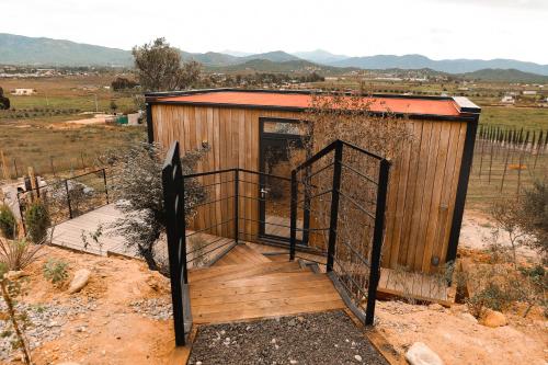 a small wooden building with a wooden gate at Bajo Estrellas Hotel Contemporáneo in Valle de Guadalupe