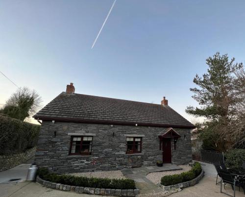 a stone house with a table and chairs in front of it at Hollymount Cottage in Cranley