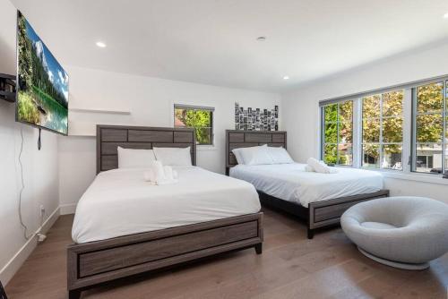 a bedroom with two beds and a chair and window at Prestigious 5BR Mansion w/ Pool, Theatre & Jacuzzi in Los Angeles