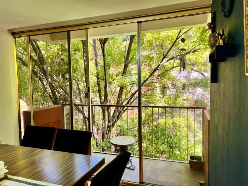 a room with a table and a large window at Casa Camara in Mexico City