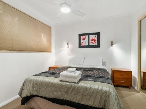 a bedroom with a bed with two towels on it at Yarrawonga Lakeside Apartment 25 in Mulwala