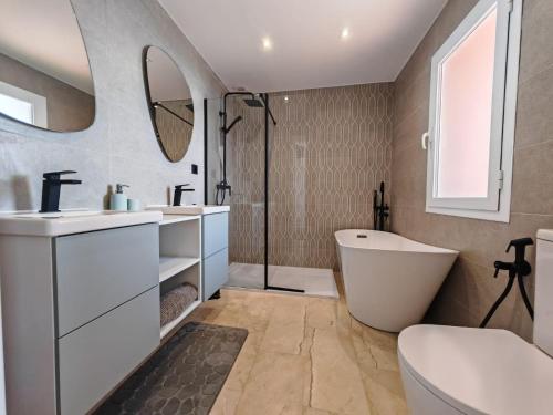 a bathroom with a tub and a toilet and a sink at Beachfront Townhouse Estepona in Estepona