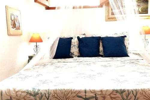 a bedroom with a large bed with blue pillows at Ampio appartamento mare in Putzu Idu