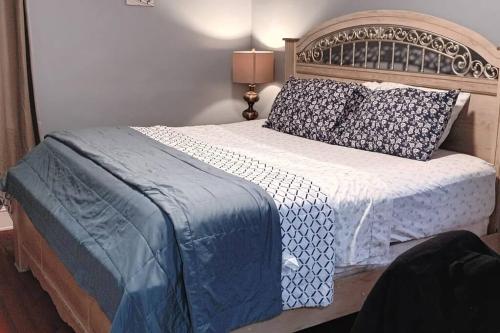 a bedroom with a large bed with blue and white sheets at Calm 3 Bedroom apartment in Newark