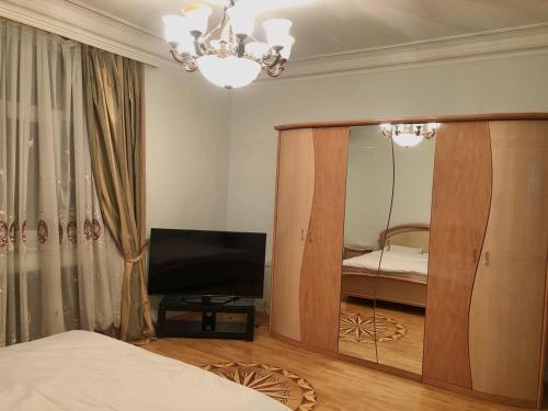 een slaapkamer met een spiegel, een bed en een televisie bij Luxury villa 8 bedrooms in Baku