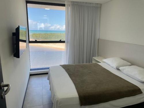 - une chambre avec un lit et une vue sur l'océan dans l'établissement Hosts BR - Frente Mar c/ cozinha, à Récife