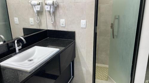La salle de bains est pourvue d'un lavabo et d'une douche. dans l'établissement Hosts BR - Frente Mar c/ cozinha, à Récife