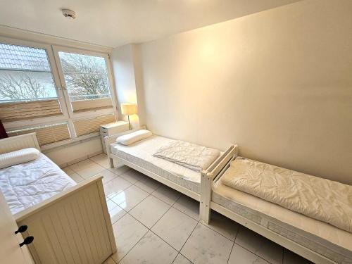 um quarto com duas camas e uma janela em Skandinavienblick-1-5-Strandstern em Hohwacht